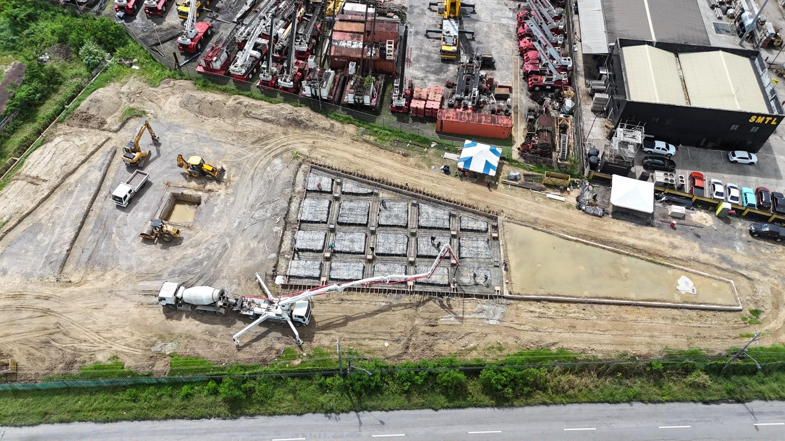 Aerial drone view of a CPML Contractors site, with a concrete pump placing a foundation alongside excavators